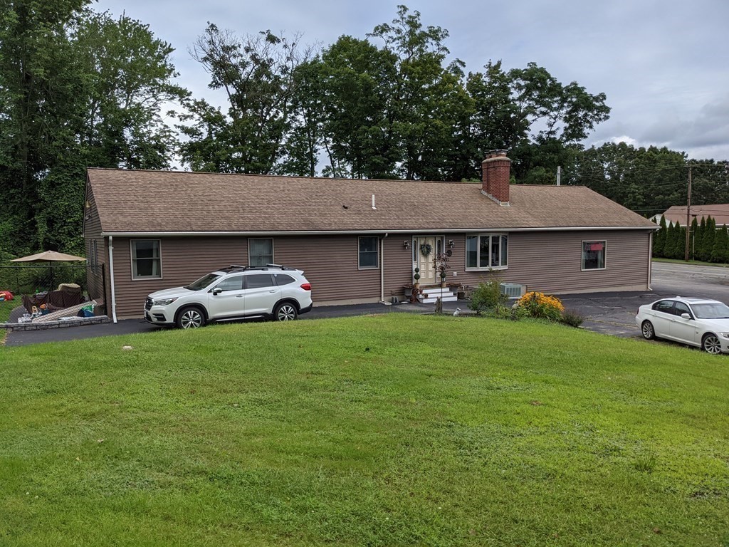 116-120 Thompson Road Webster, MA 01570 - Photo 31 of 39 a front view of a house with a garden and trees