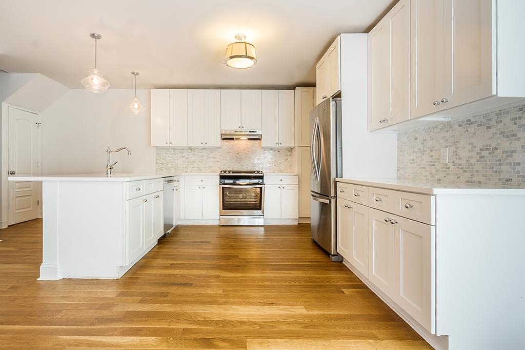 a large kitchen with white cabinets