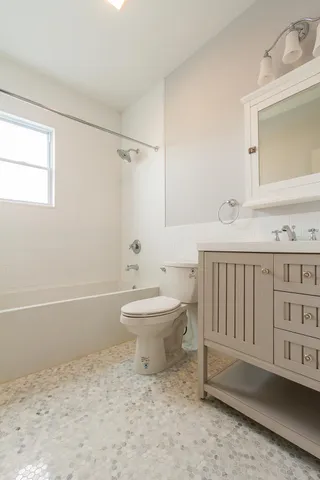 a bathroom with a toilet a sink a mirror and bathtub