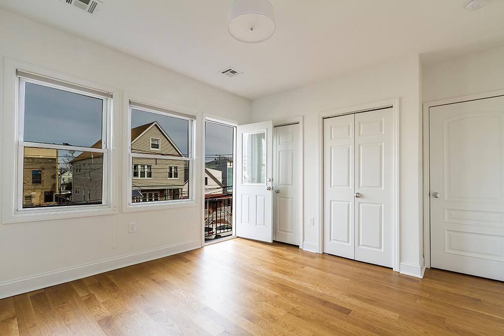 40 West 19th Street Bayonne, NJ 07002 - Photo 16 of 37 a view of empty room with window and wooden floor