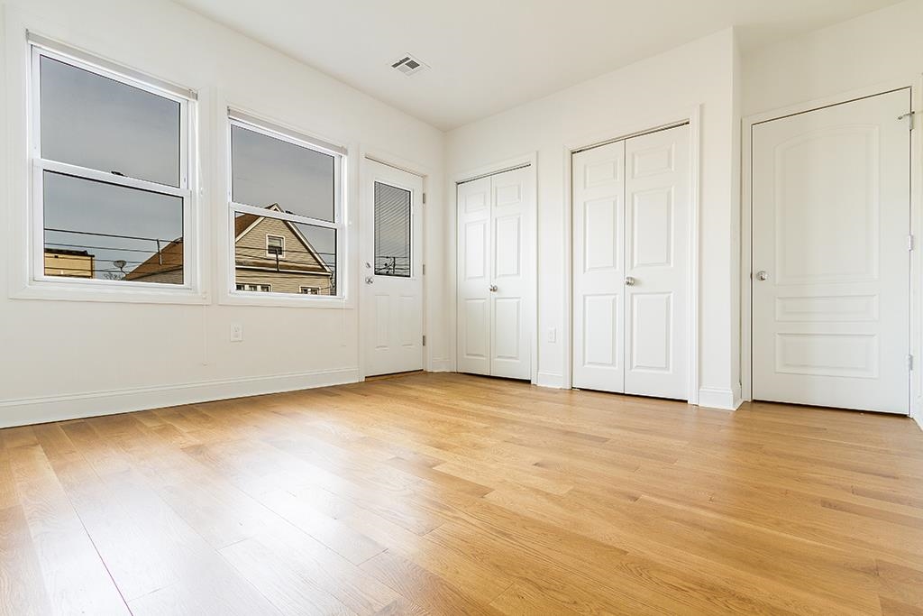 40 West 19th Street Bayonne, NJ 07002 - Photo 20 of 37 a view of an empty room with window and wooden floor