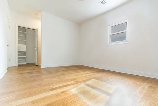 a view of a room with wooden floor and window