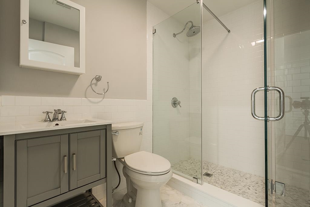 40 West 19th Street Bayonne, NJ 07002 - Photo 29 of 37 a bathroom with a toilet sink vanity and shower