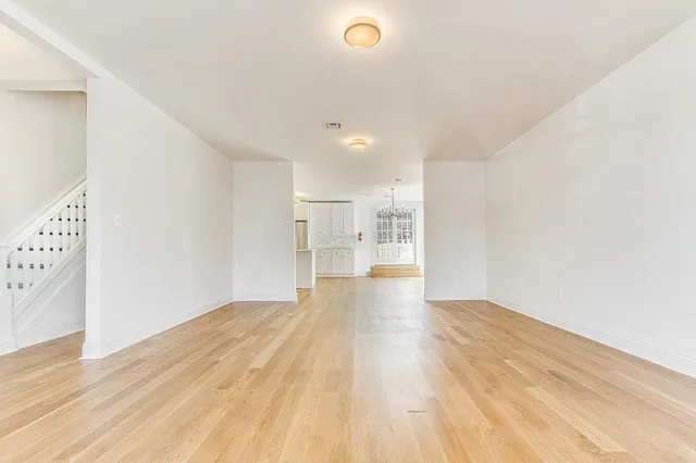 a view of empty room with wooden floor