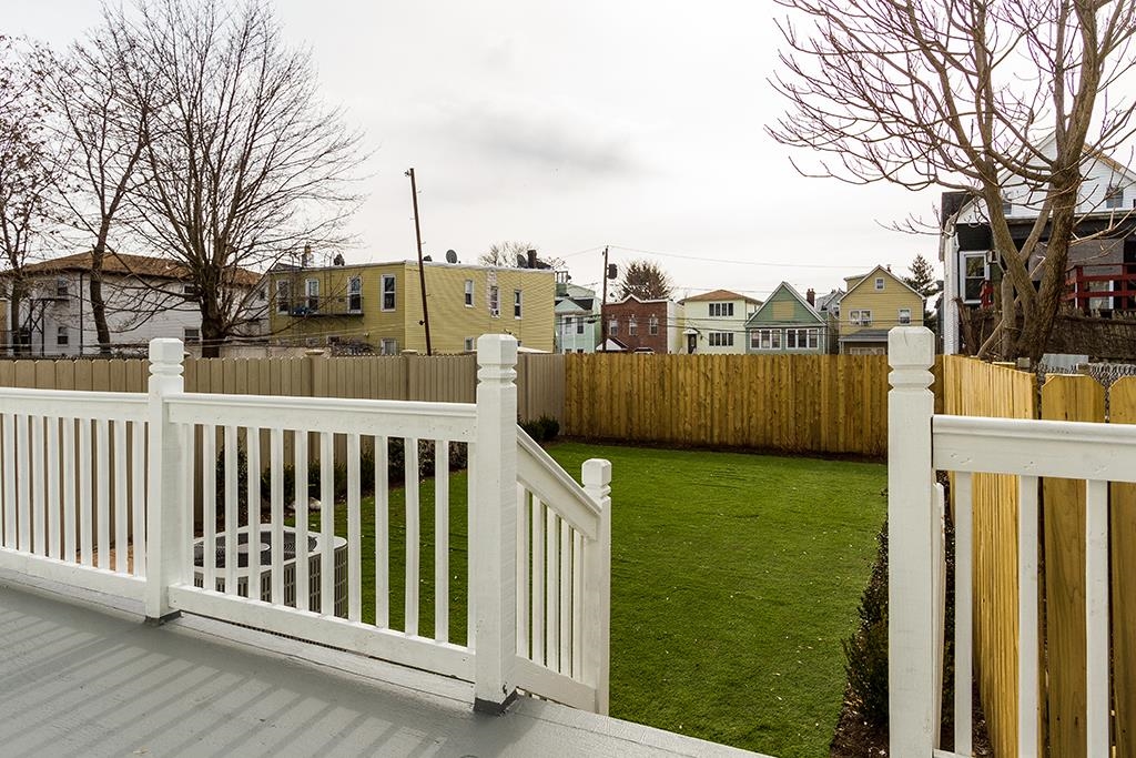 40 West 19th Street Bayonne, NJ 07002 - Photo 34 of 37 a view of a deck with large trees and wooden fence