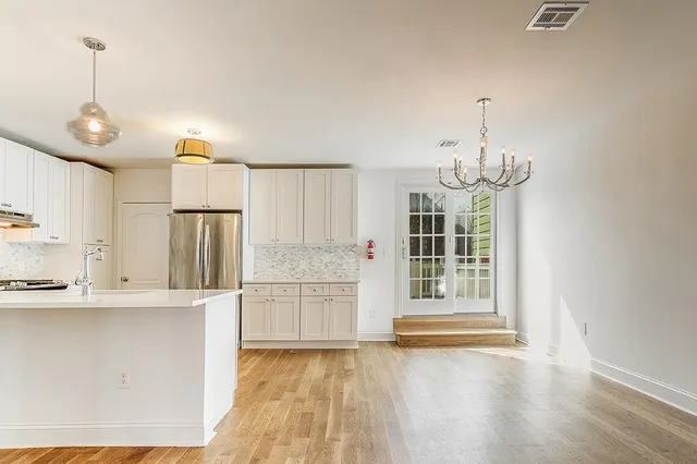 a view of a kitchen with a sink wooden cabinet and a refrigerator