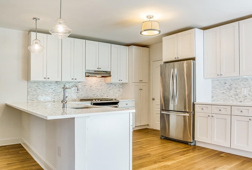 40 West 19th Street Bayonne, NJ 07002 - Photo 6 of 37 a kitchen with granite countertop a refrigerator a sink and white cabinets