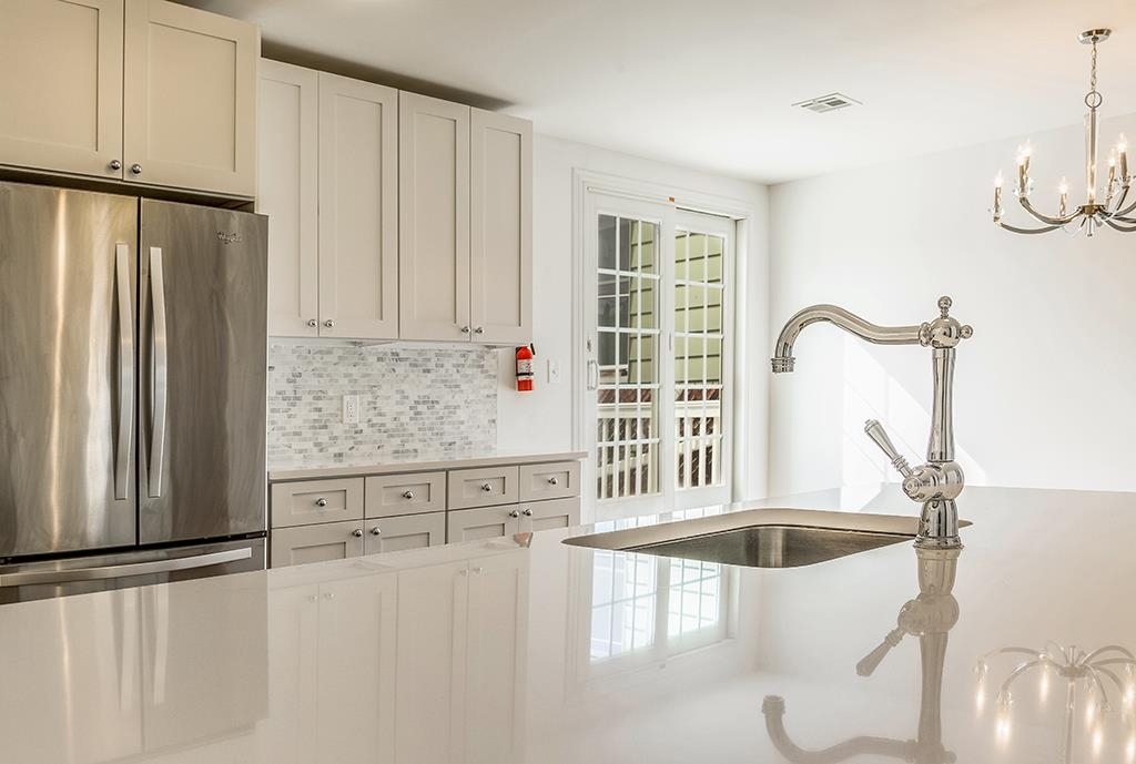 40 West 19th Street Bayonne, NJ 07002 - Photo 7 of 37 a kitchen with stainless steel appliances granite countertop a refrigerator a sink a stove and white cabinets with wooden floor