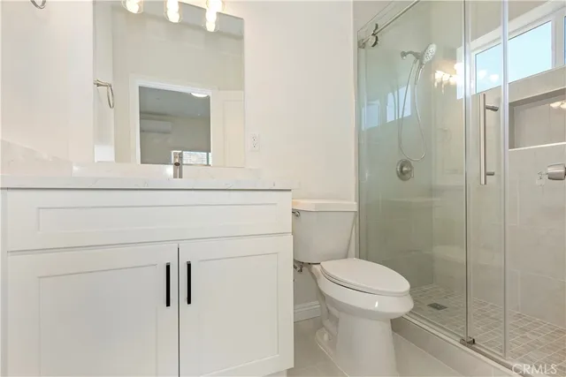 a bathroom with a sink toilet vanity and shower