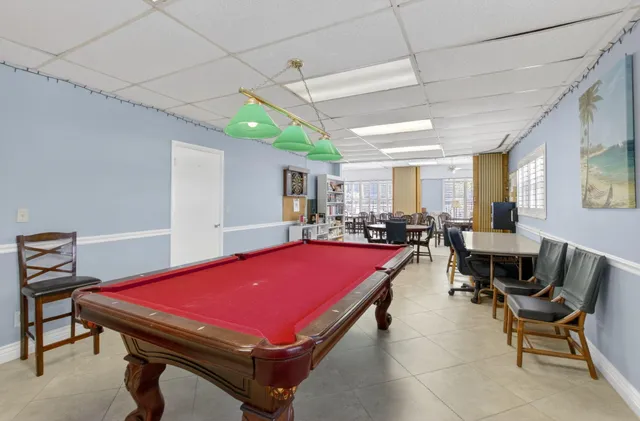 a room with furniture pool table and windows
