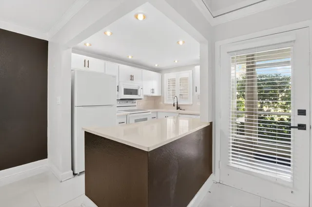 a kitchen with kitchen island a sink stainless steel appliances and cabinets