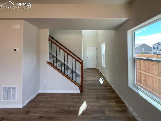 a view of a hallway with wooden floor and staircase