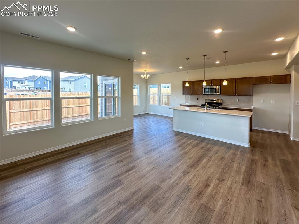 10820 Raylan Way Peyton, CO 80831 - Photo 4 of 35 a view of a big room with wooden floor and windows