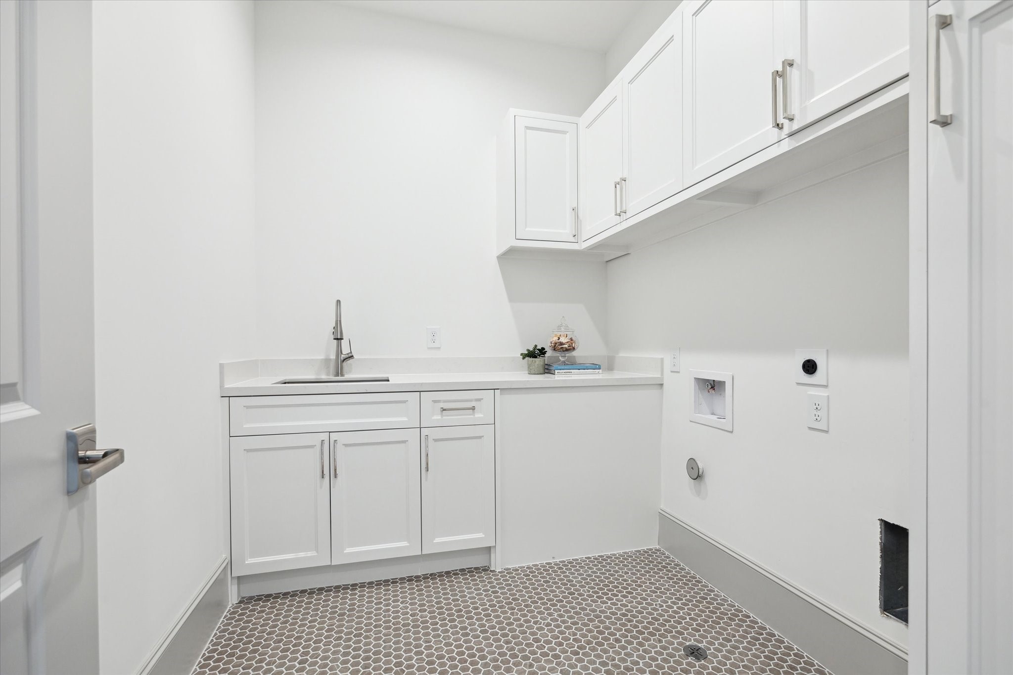 207 Sutton Row Place Houston, TX 77024 - Photo 20 of 29 Second-floor utility room features Plover Carrara Quartz countertops, sink and cabinet storage.