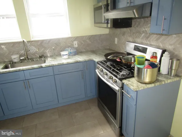a kitchen with a sink a stove and cabinets