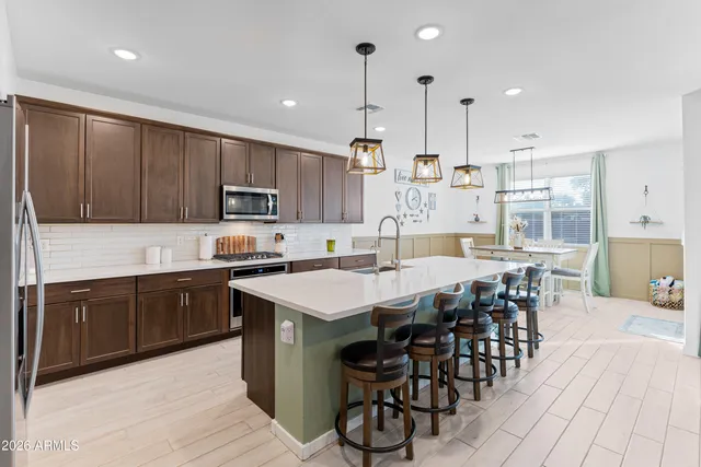 a dining room with furniture a chandelier and wooden floor