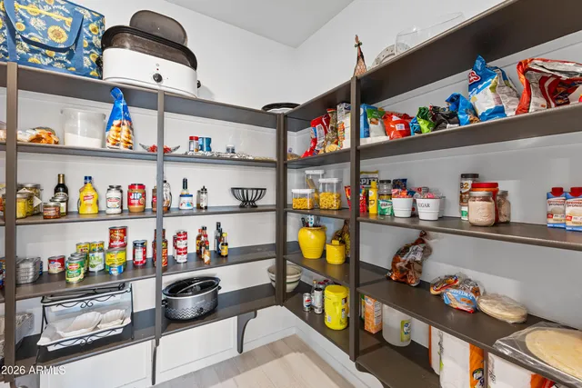 a large kitchen with stainless steel appliances a stove a sink dishwasher and a refrigerator with wooden floor