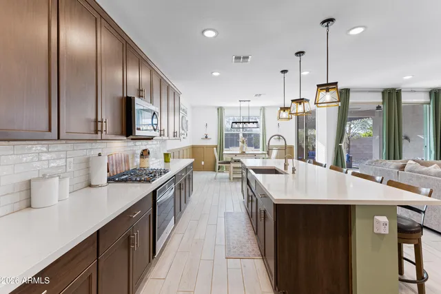 a kitchen with stainless steel appliances kitchen island granite countertop a sink a stove and a refrigerator