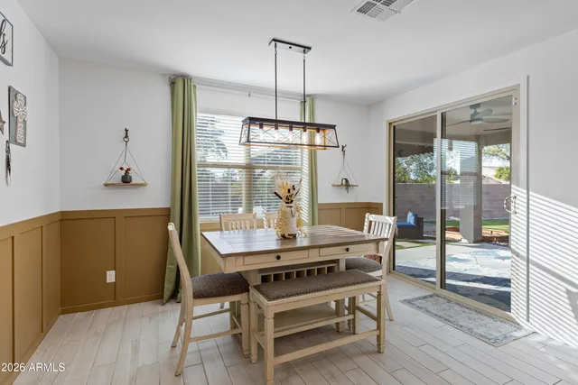a kitchen with granite countertop a table chairs microwave and refrigerator
