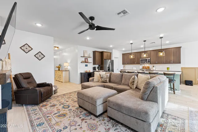 a kitchen with stainless steel appliances kitchen island granite countertop a table chairs sink and cabinets