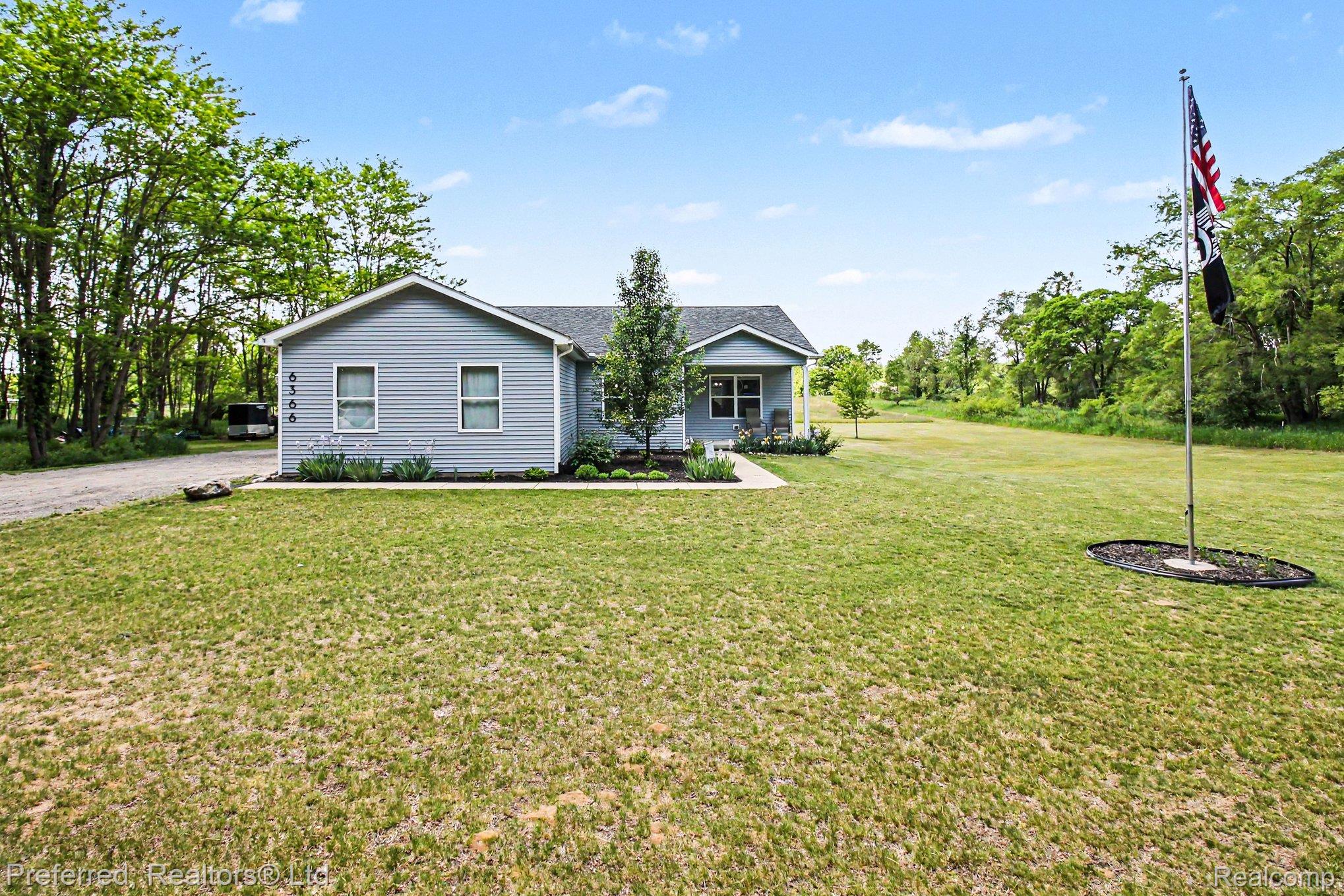 6366 Dutcher Road Howell, MI 48843 - Photo 32 of 33 Ranch-style exterior with light blue siding, a dark shingled roof, and white-trimmed windows