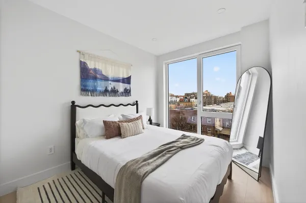 a bedroom with a bed a mirror and lamp