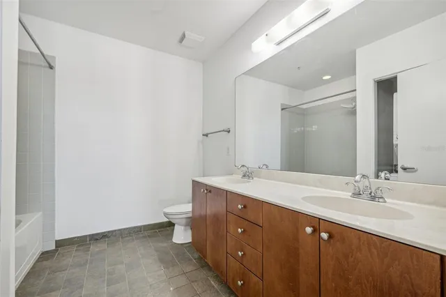 a spacious bathroom with a double vanity sink a mirror and a