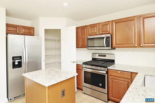 a kitchen with granite countertop a refrigerator stove and microwave