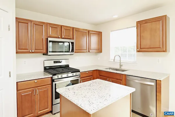 a kitchen with granite countertop a sink stove and microwave