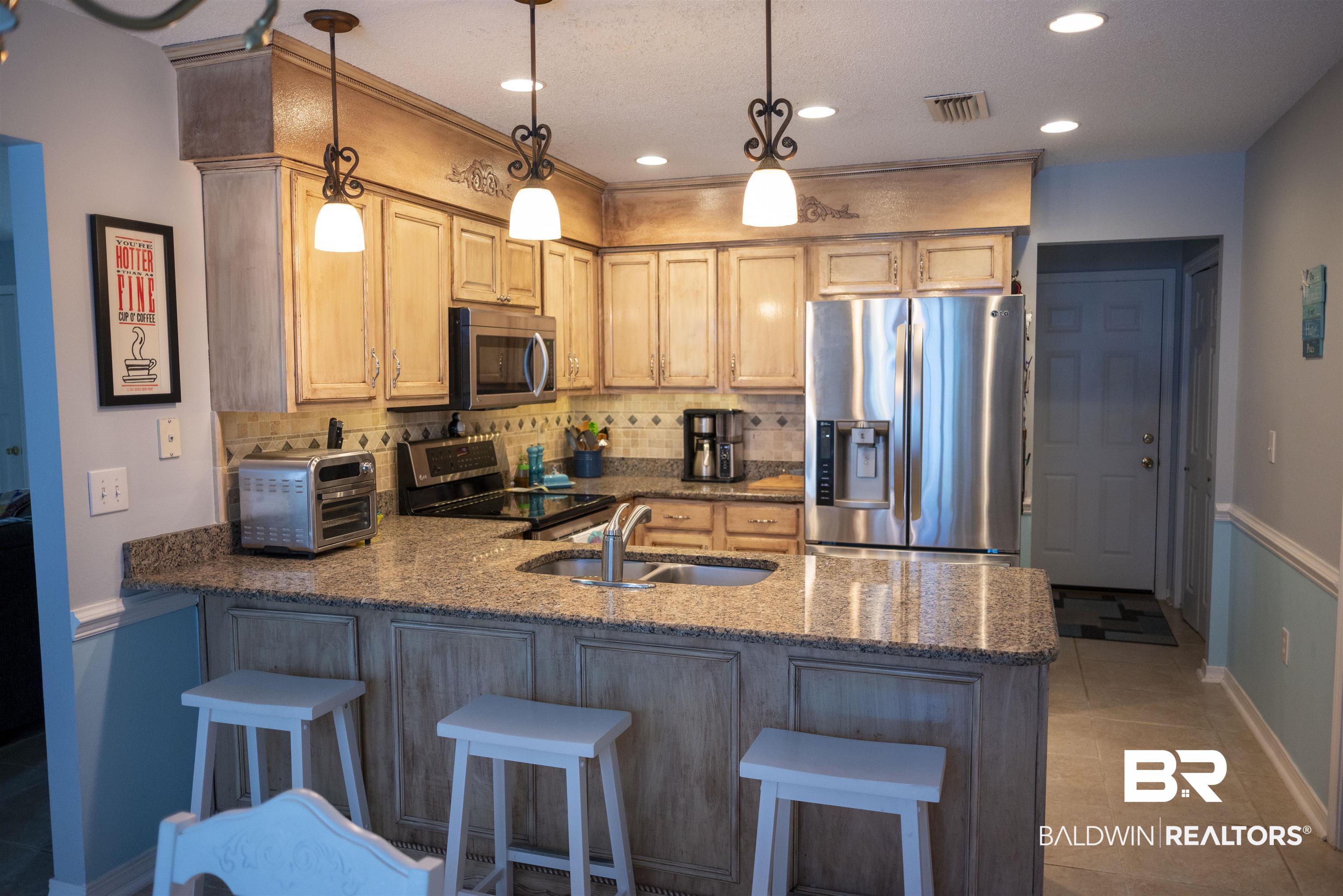 808 Wisteria Lane Foley, AL 36535 - Photo 7 of 19 Kitchen featuring sink, kitchen peninsula, hanging light fixtures, decorative backsplash, and stainless steel appliances
