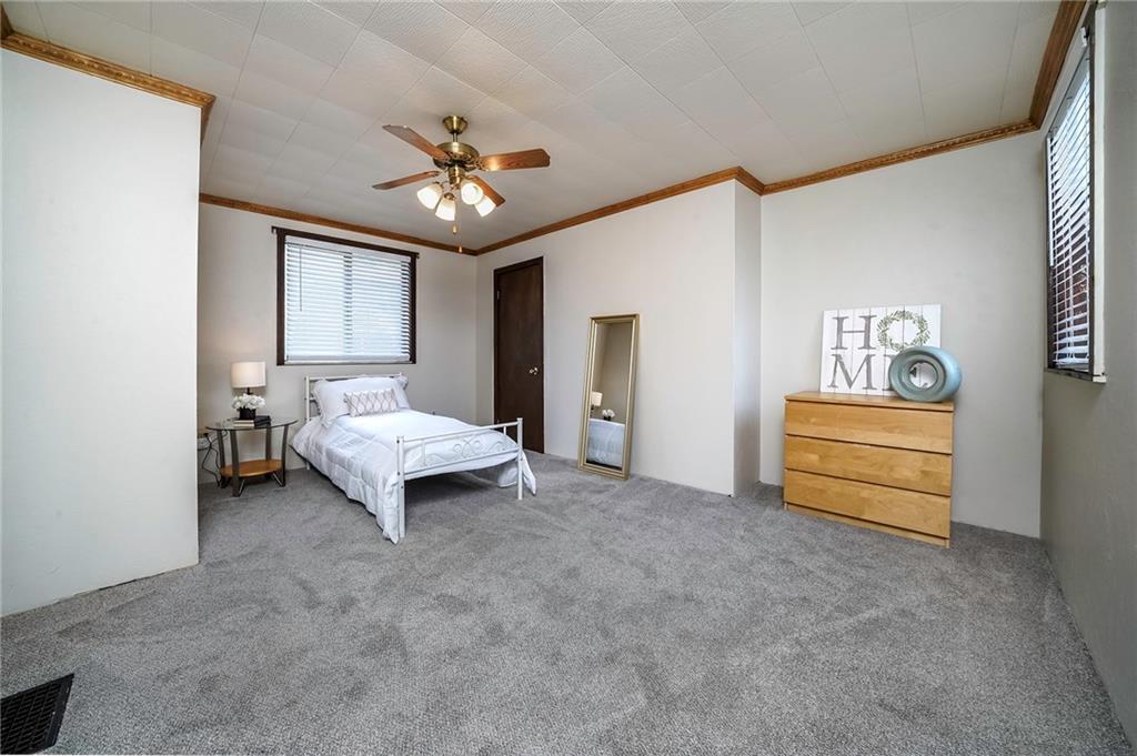 805 Frank Street McKees Rocks, PA 15136 - Photo 16 of 25 a spacious bedroom with a bed and ceiling fan