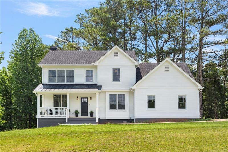 a front view of a house with garden and trees