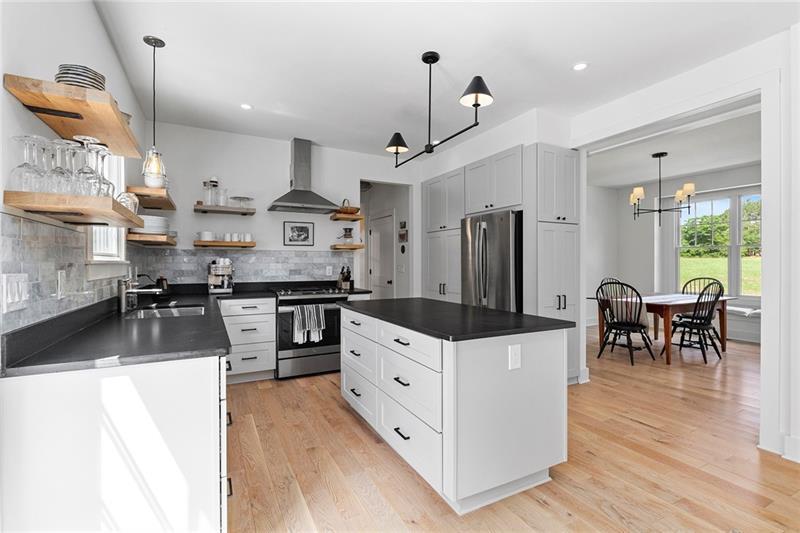 7600 Barnes Road Palmetto, GA 30268 - Photo 17 of 37 a kitchen with stainless steel appliances kitchen island granite countertop a table chairs and a refrigerator