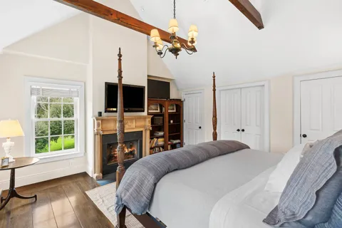 a bedroom with a bed window and a fireplace