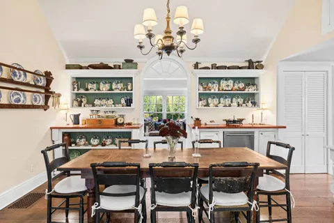 a view of a dining room with furniture a chandelier and wooden floor