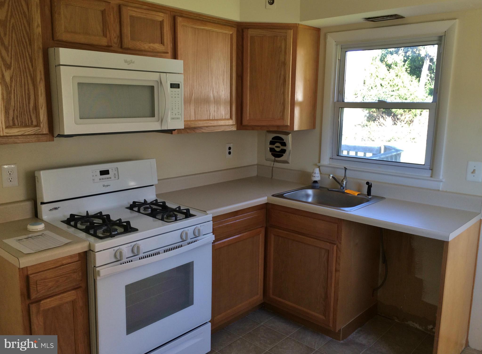 2115 Gaybrook Road Baltimore, MD 21244 - Photo 2 of 10 a kitchen with cabinets appliances a sink and a window