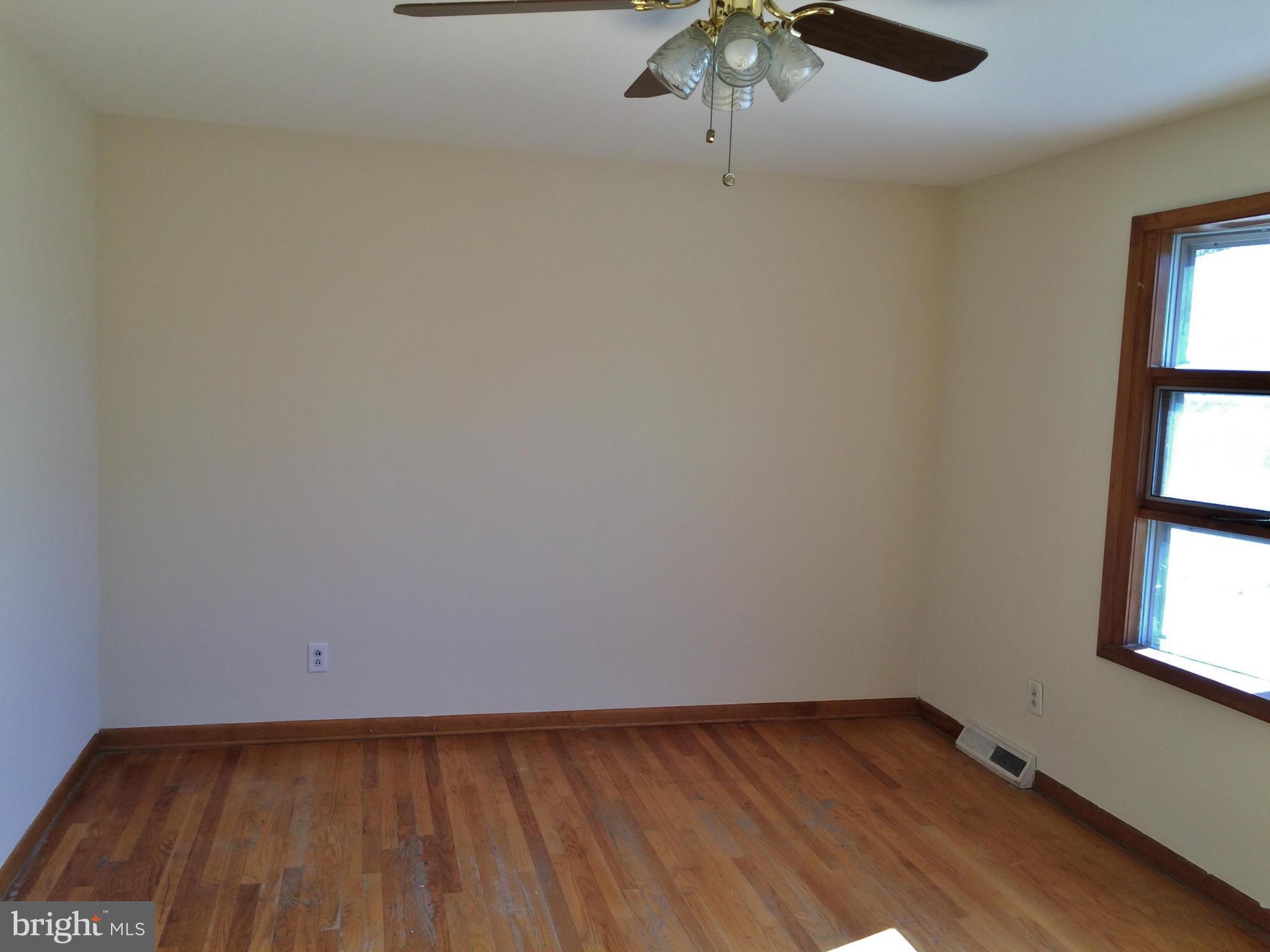 2115 Gaybrook Road Baltimore, MD 21244 - Photo 4 of 10 an empty room with a window and wooden floor