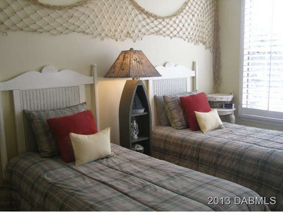 4623 Rivers Edge Village Lane, Unit 6208 Ponce Inlet, FL 32127 - Photo 12 of 23 a bedroom with a bed and a lamp