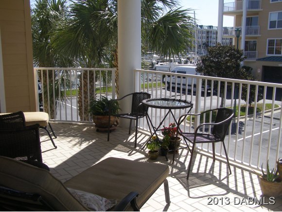 4623 Rivers Edge Village Lane, Unit 6208 Ponce Inlet, FL 32127 - Photo 14 of 23 a view of a balcony with chairs and wooden floor