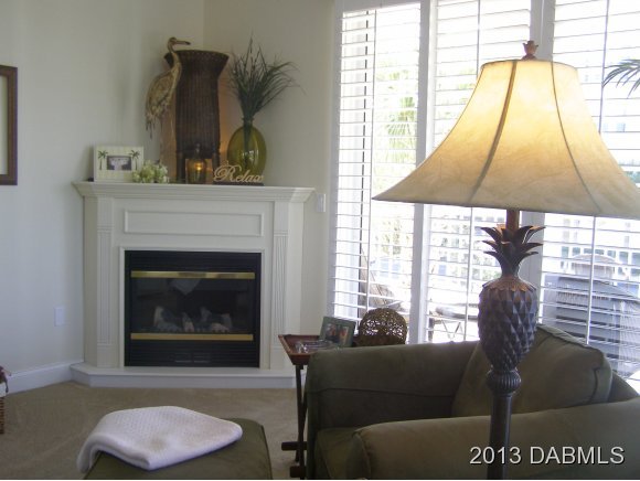 4623 Rivers Edge Village Lane, Unit 6208 Ponce Inlet, FL 32127 - Photo 4 of 23 a living room with furniture and a fireplace