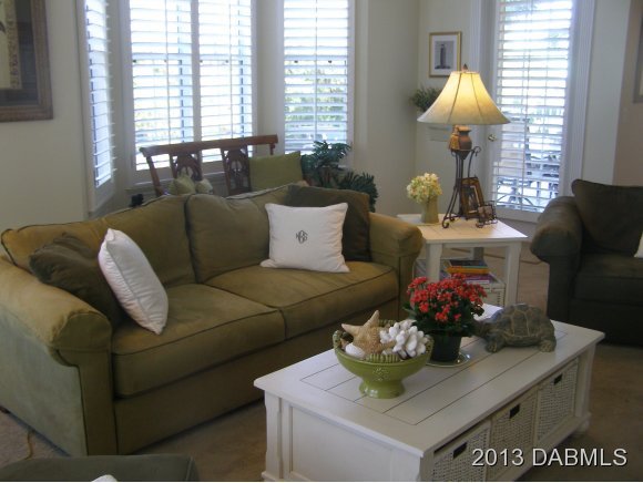 4623 Rivers Edge Village Lane, Unit 6208 Ponce Inlet, FL 32127 - Photo 8 of 23 a living room with furniture and a table