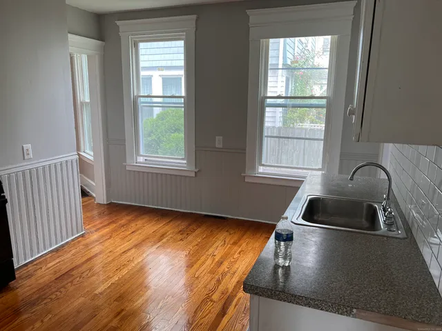 a kitchen with granite countertop a sink stove and cabinets