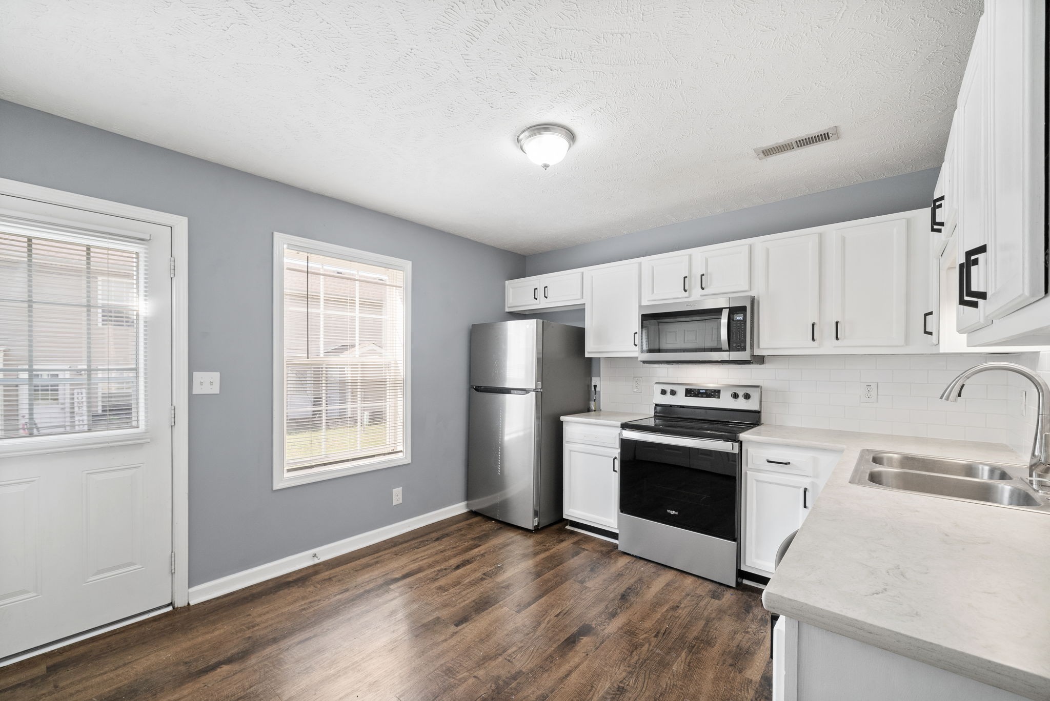 249 Executive Avenue, Unit B Clarksville, TN 37042 - Photo 8 of 13 a kitchen with stainless steel appliances granite countertop a stove a sink dishwasher a refrigerator and a microwave oven with white cabinets