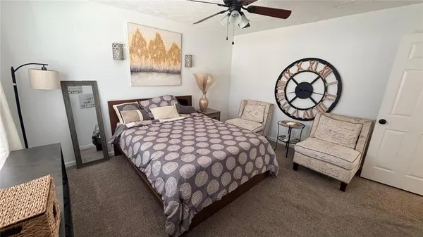 a bedroom with a bed a mirror on dresser and a table