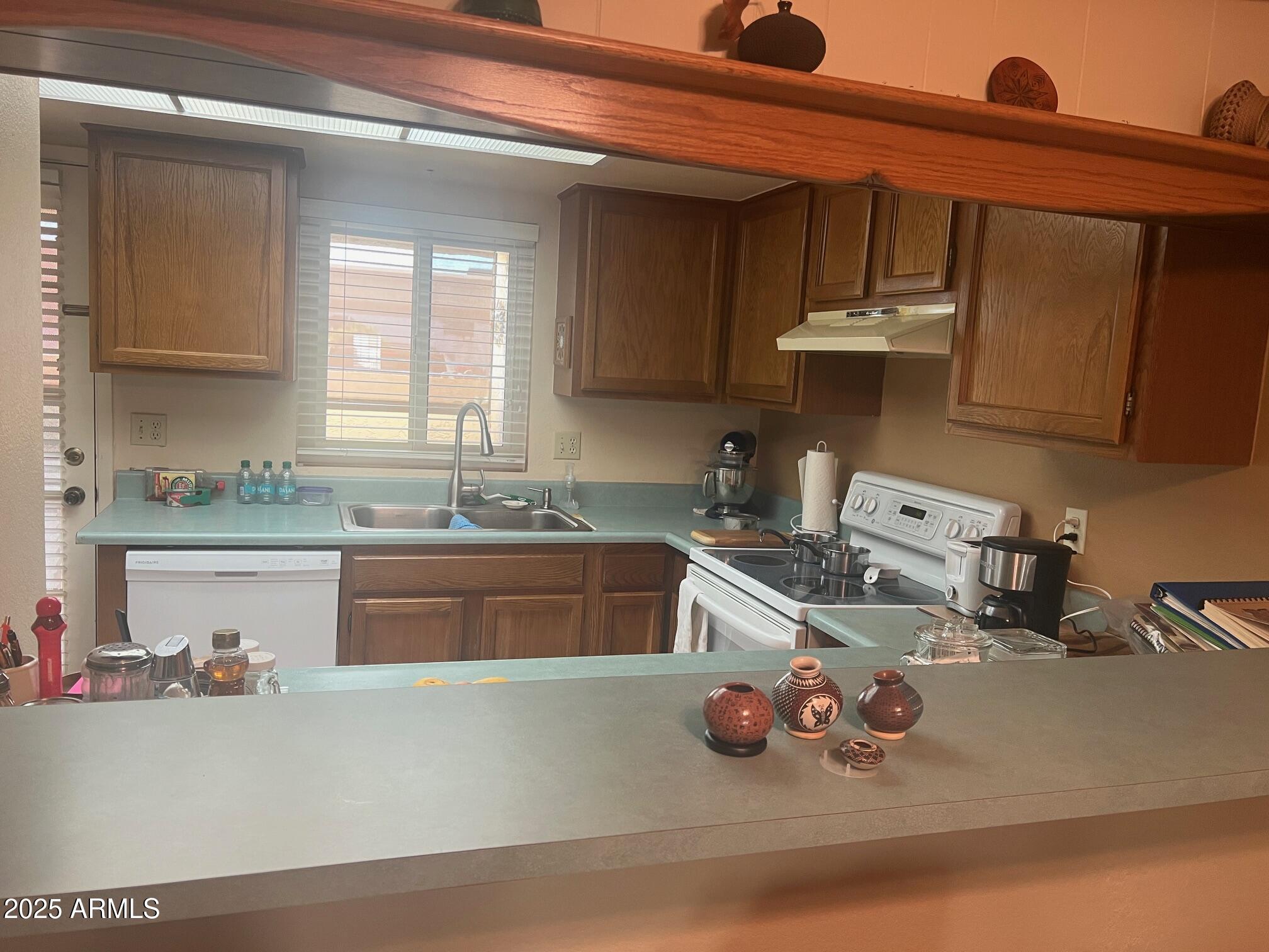 5518 East Lindstrom Lane, Unit 1044 Mesa, AZ 85215 - Photo 12 of 30 a kitchen with a sink a stove and cabinets