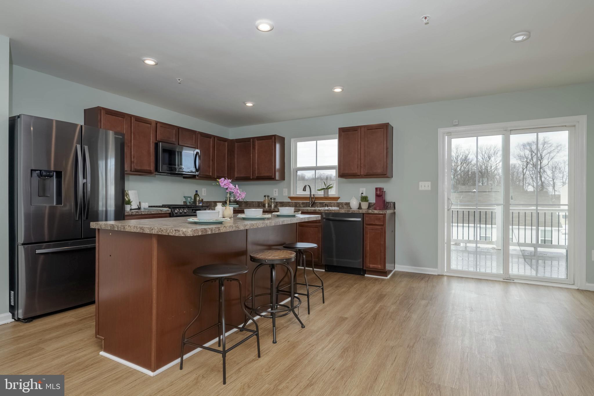 10114 Blansford Way Middle River, MD 21220 - Photo 8 of 41 a kitchen with stainless steel appliances granite countertop a refrigerator a stove a sink dishwasher and a microwave with wooden floor