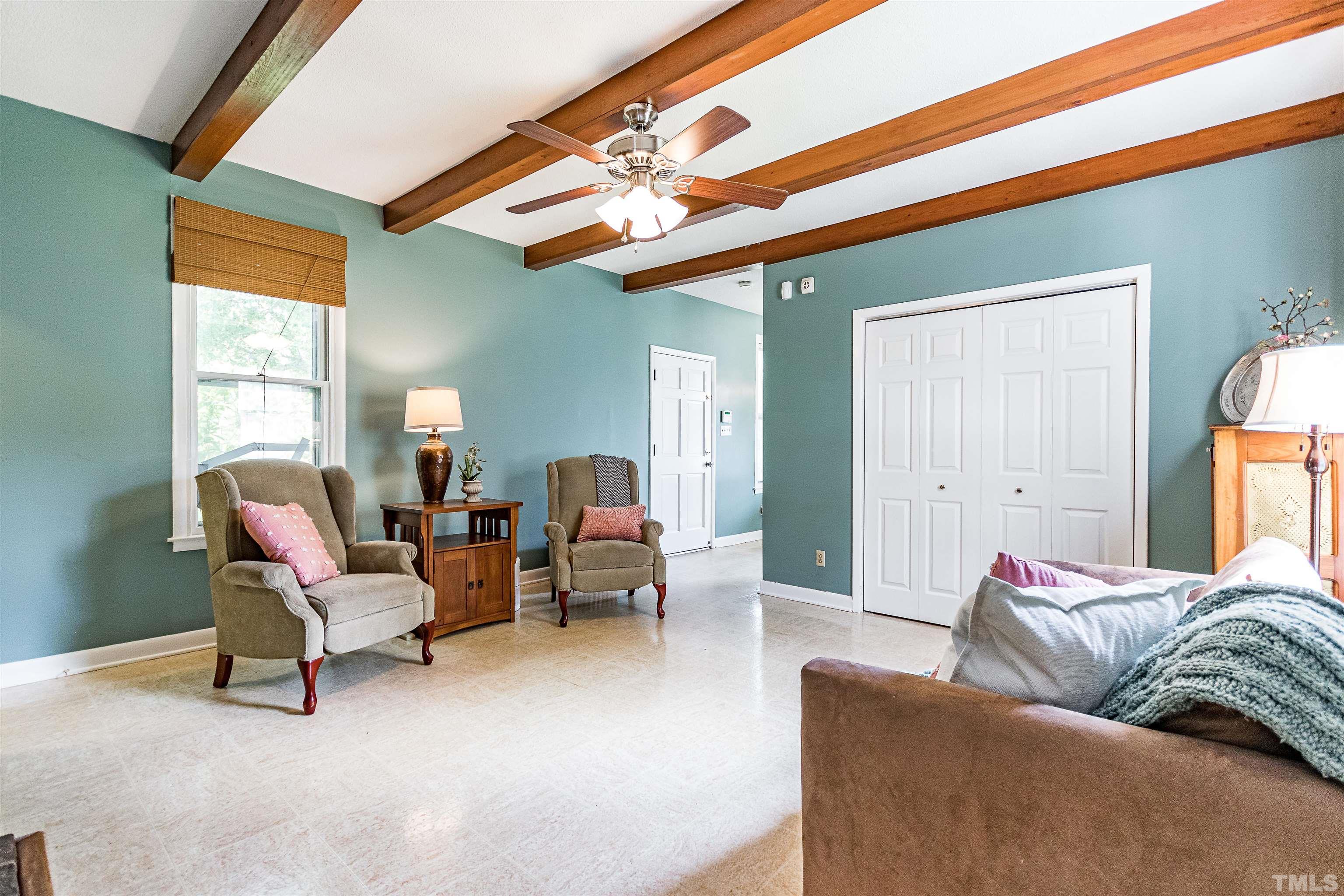 6467 Cleveland Road Clayton, NC 27520 - Photo 15 of 54 Through the dining room you enter into the den, this cozy room with exposed wood beams, a wood burning fireplace, access to a full bathroom, laundry and flows into eat in kitchen.