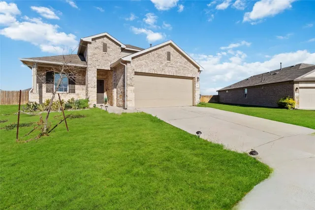 a view of a house with a yard and sitting area