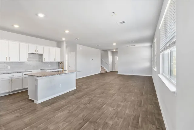 a large kitchen with stainless steel appliances granite countertop a large counter top a sink and a stove