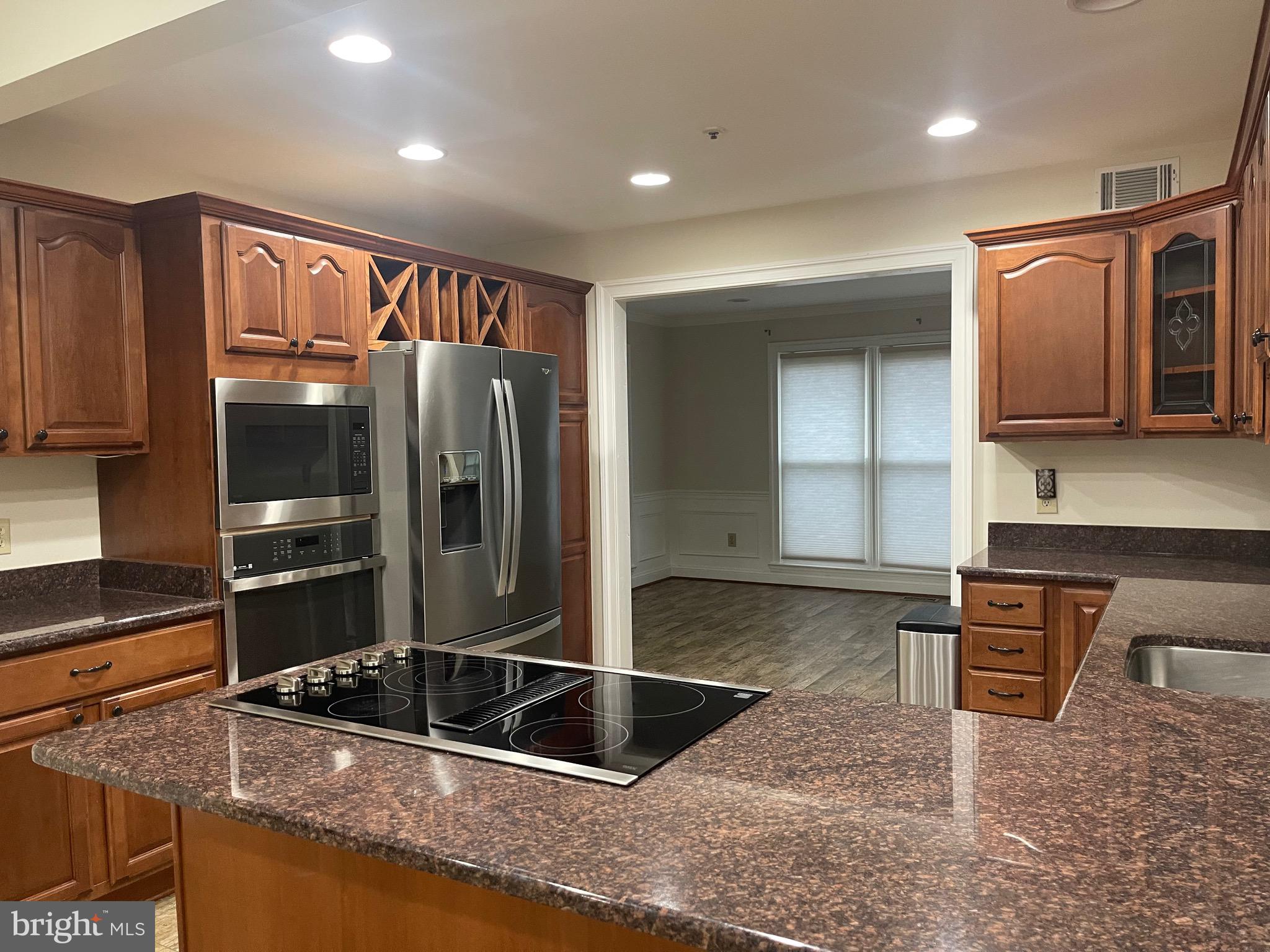 11803 Bishops Content Road Bowie, MD 20721 - Photo 15 of 54 a kitchen with granite countertop a refrigerator and a stove top oven